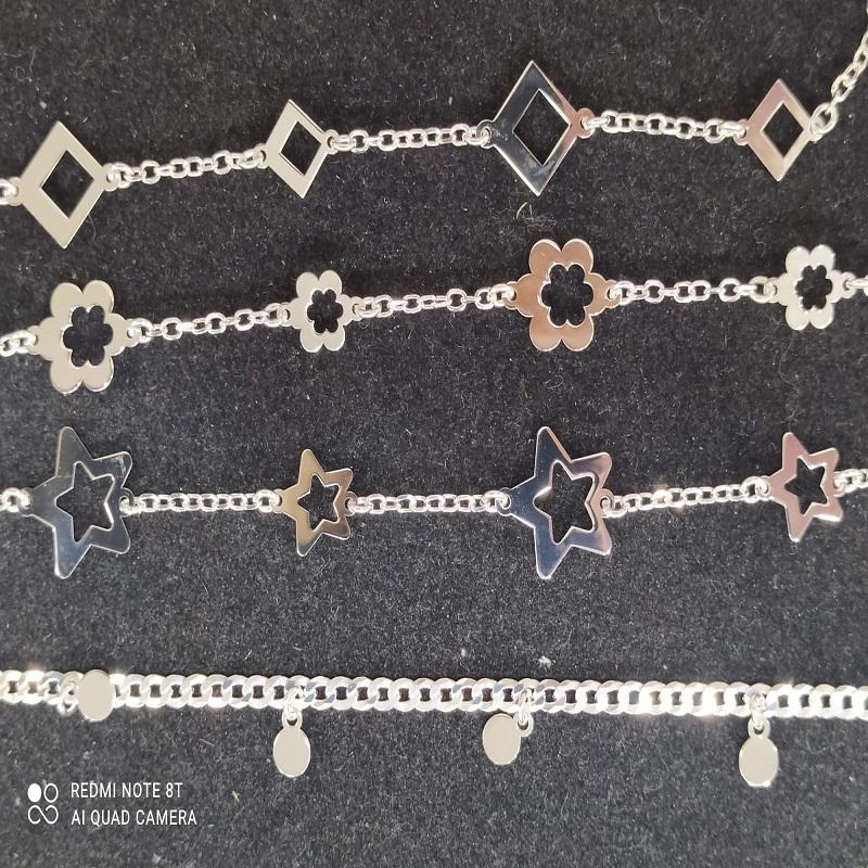 Cadena de joyería con flores sobre un fondo negro, primer plano