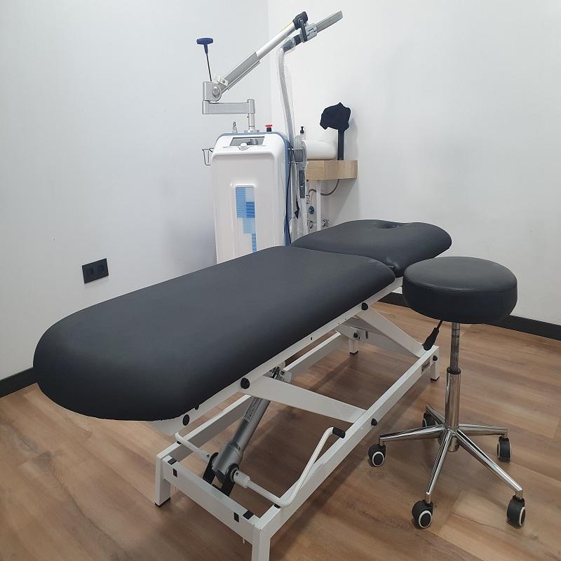 Interior de una sala de fisioterapia con una camilla para masajes