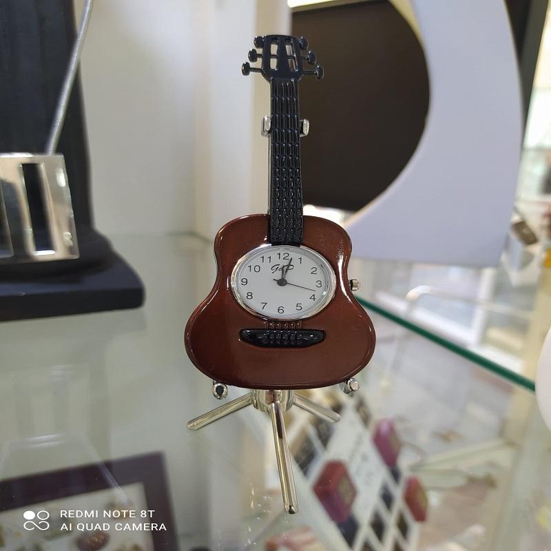 Reloj con forma de guitarra acústica retro. Concepto de música antigua.
