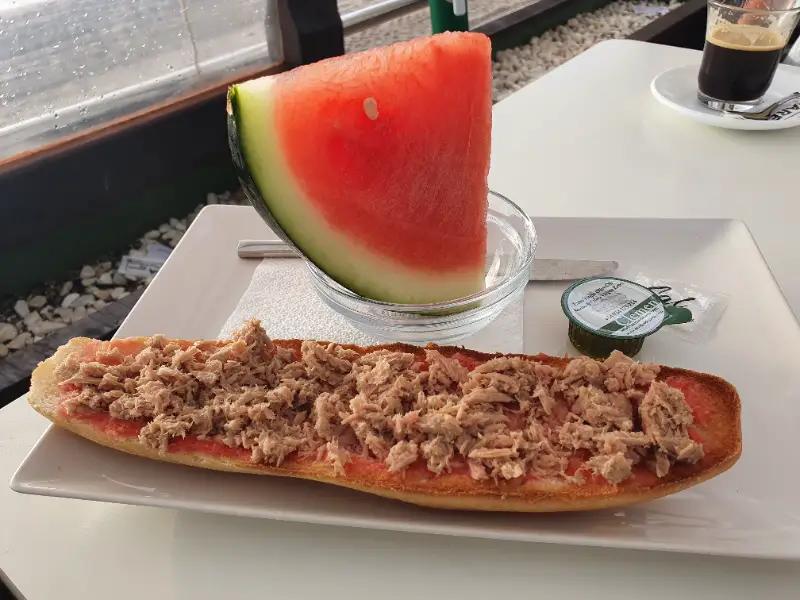 Desayudo con tostada de atún y tomate, sandía y café