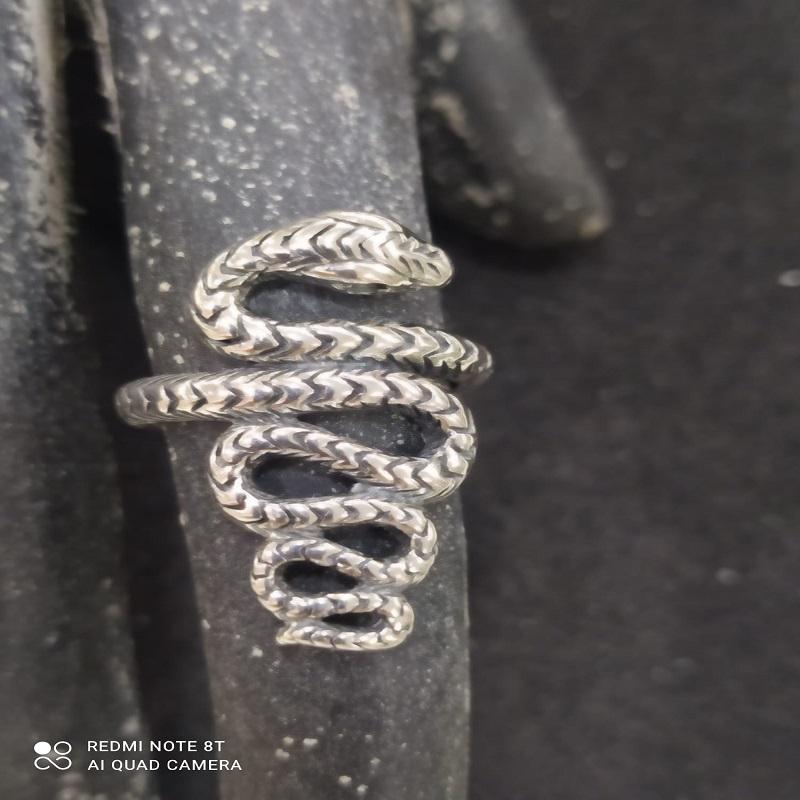 Anillo de joyería en forma de serpiente sobre un fondo negro